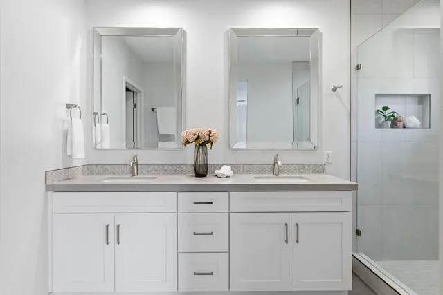 a bathroom with double sink and a mirror