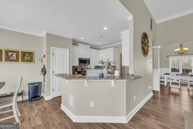 a kitchen with granite countertop white cabinets and stainless steel appliances