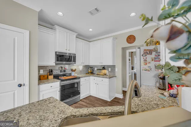 a kitchen with granite countertop a sink and a white stove
