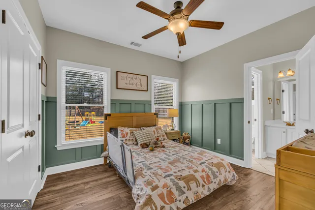 a bedroom with a bed next to a window and a chandelier
