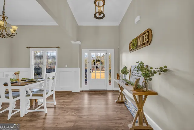 a view of a dining room with furniture a chandelier and wooden floor