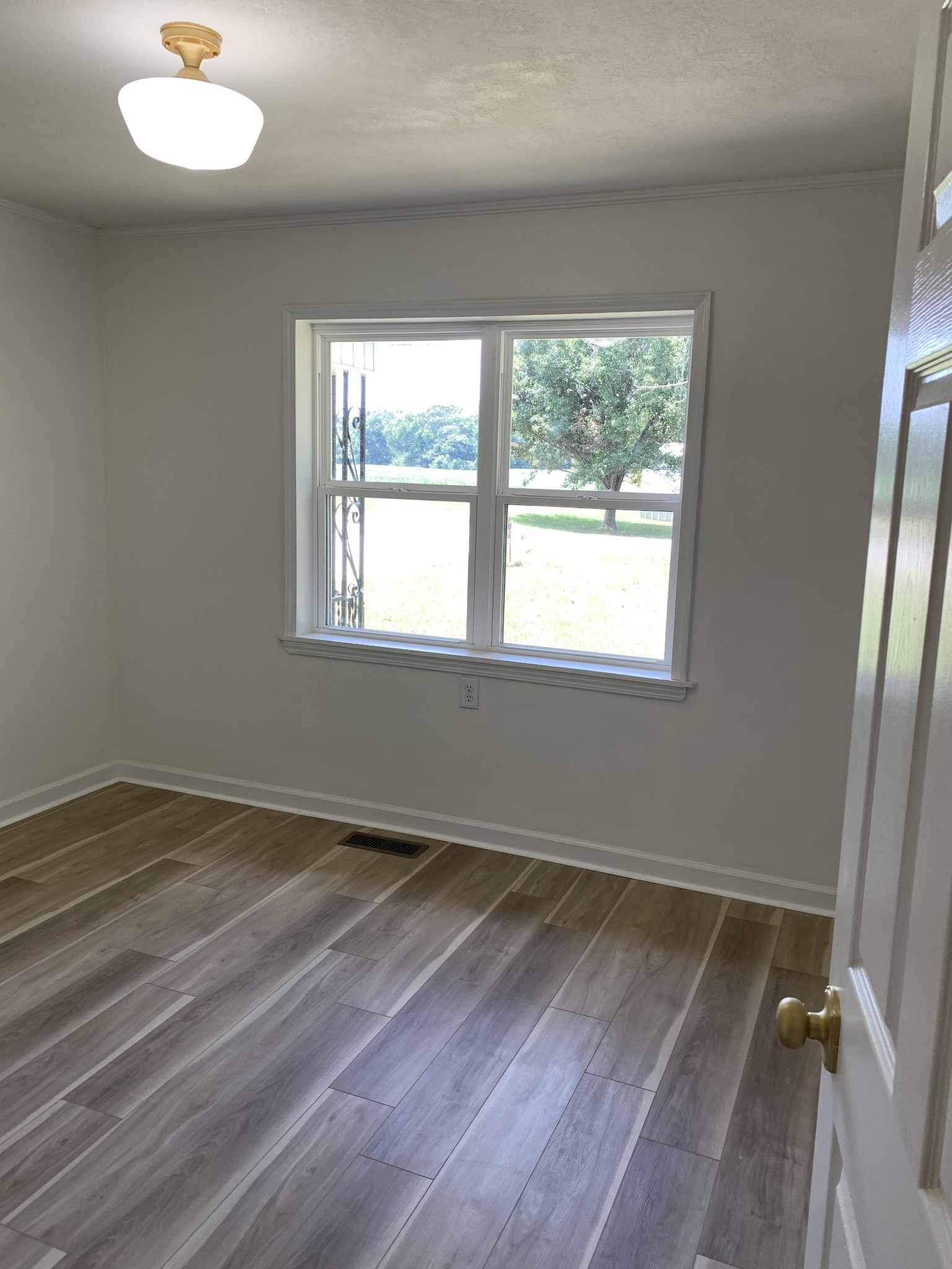 5870 Chestnut Bluff Road Friendship, TN 38034 - Photo 13 of 19 an empty room with wooden floor and windows