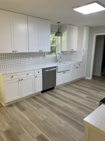 a kitchen with granite countertop white cabinets and sink