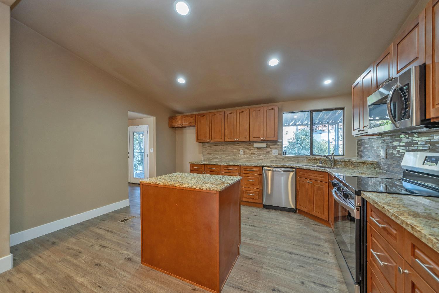 4420 Pleasant Valley Road, Unit 155 Diamond Springs, CA 95619 - Photo 16 of 42 a kitchen with stainless steel appliances granite countertop a sink a stove top oven and wooden floors