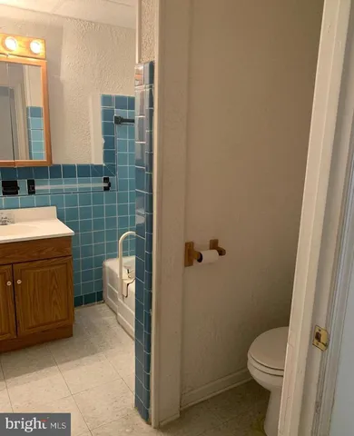 a bathroom with a granite countertop toilet and a sink