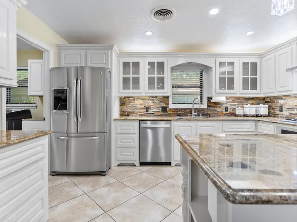 a kitchen with stainless steel appliances granite countertop a stove a sink and a refrigerator