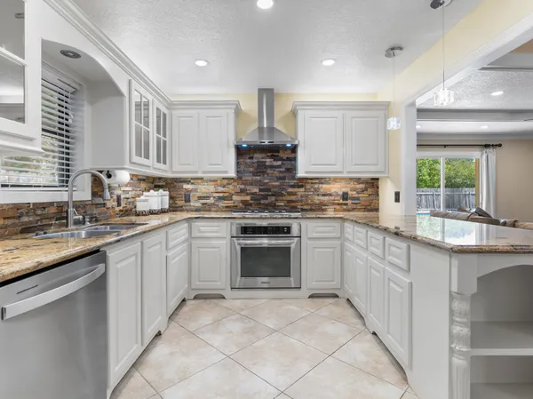 a kitchen with stainless steel appliances granite countertop a stove sink and cabinets