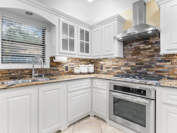 a kitchen with granite countertop a sink stainless steel appliances and cabinets