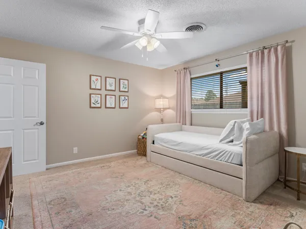 a spacious bedroom with a bed and dresser