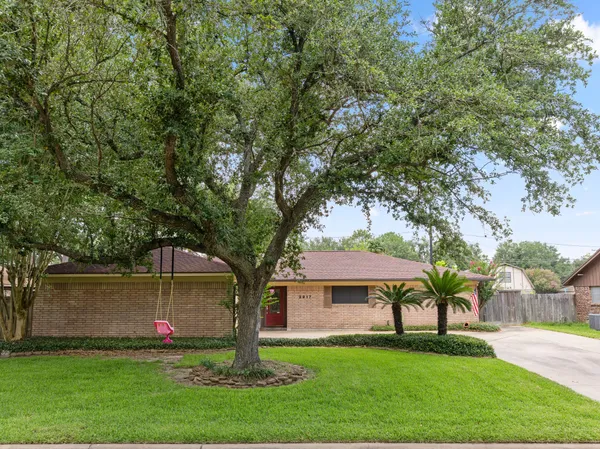 a front view of a house with a garden and trees