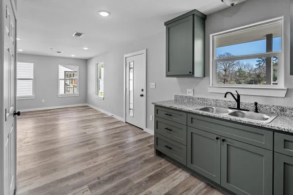 a bathroom with a granite countertop sink mirror and window