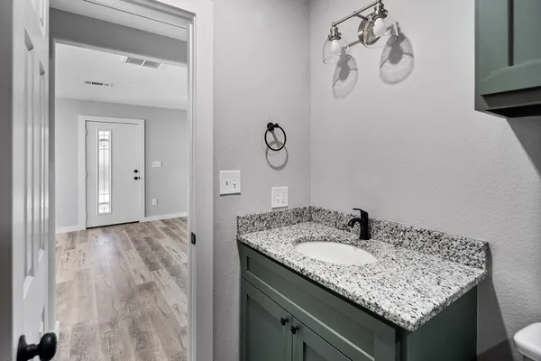 a bathroom with a granite countertop sink and a mirror