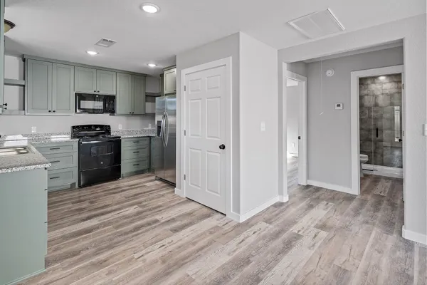 a kitchen with stainless steel appliances granite countertop a refrigerator stove top oven and sink