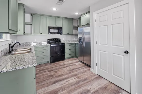 a kitchen with stainless steel appliances granite countertop a refrigerator sink and stove