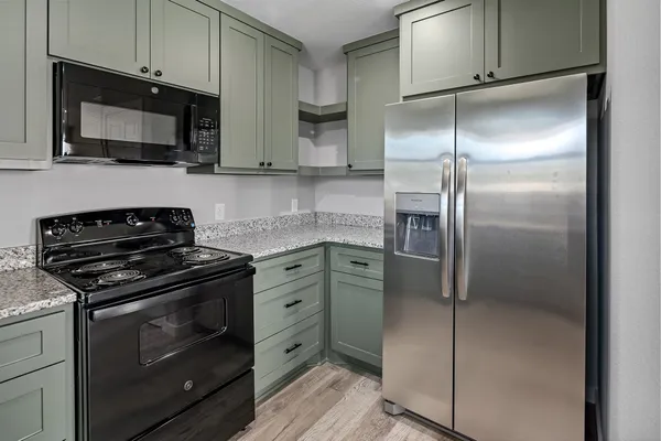 a kitchen with stainless steel appliances granite countertop a refrigerator stove and microwave