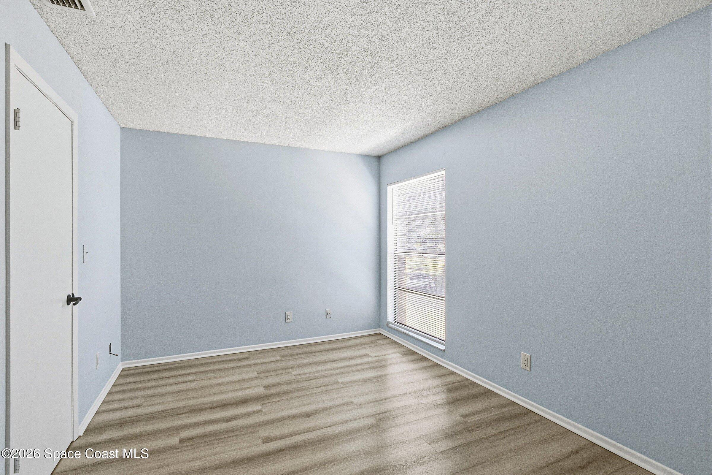 1225 North Wickham Road, Unit 223 Melbourne, FL 32935 - Photo 12 of 26 a view of room with window and wooden floor