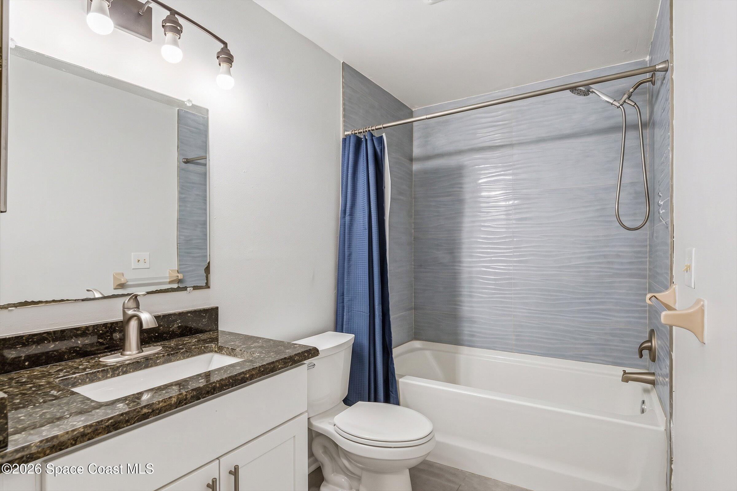 1225 North Wickham Road, Unit 223 Melbourne, FL 32935 - Photo 13 of 26 a bathroom with a granite countertop sink toilet and shower