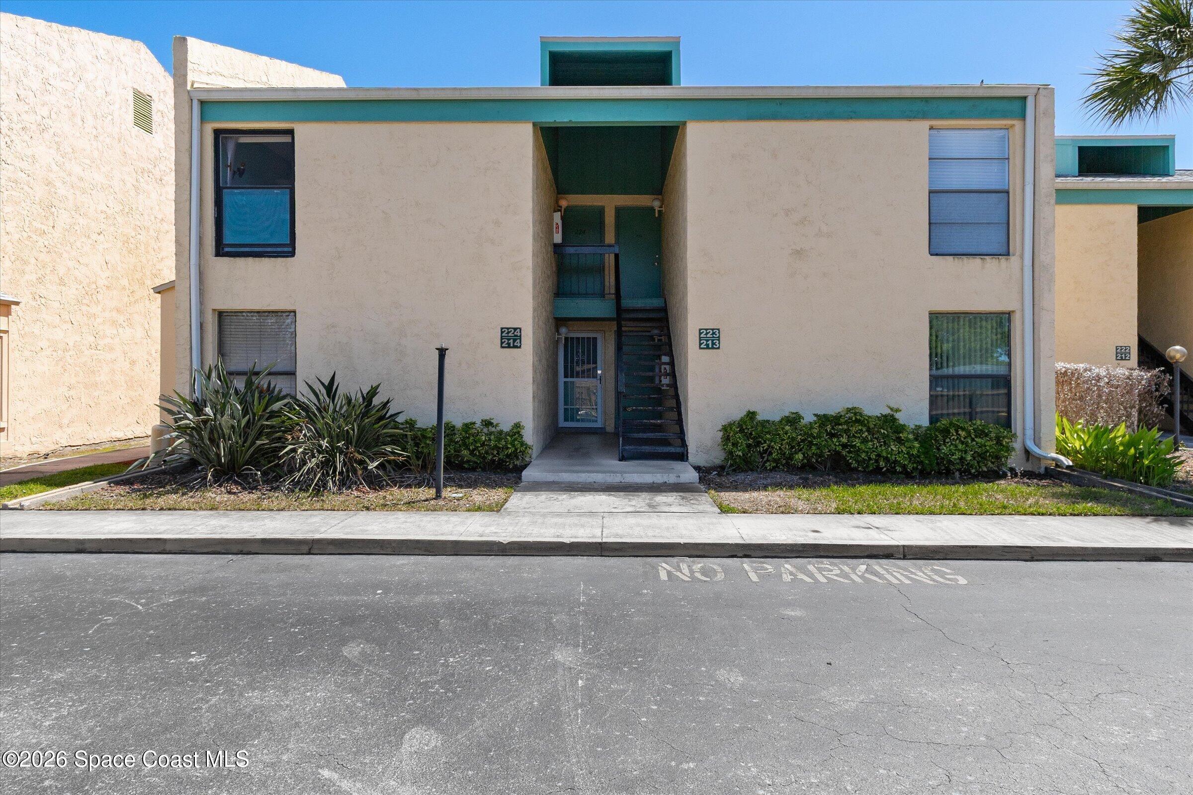 1225 North Wickham Road, Unit 223 Melbourne, FL 32935 - Photo 3 of 26 a view of a house with a yard and a street