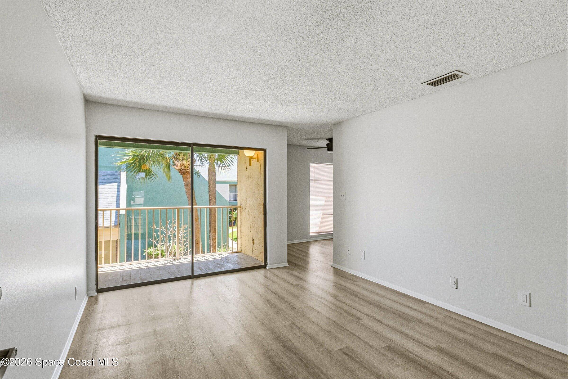1225 North Wickham Road, Unit 223 Melbourne, FL 32935 - Photo 4 of 26 wooden floor in an empty room with a window