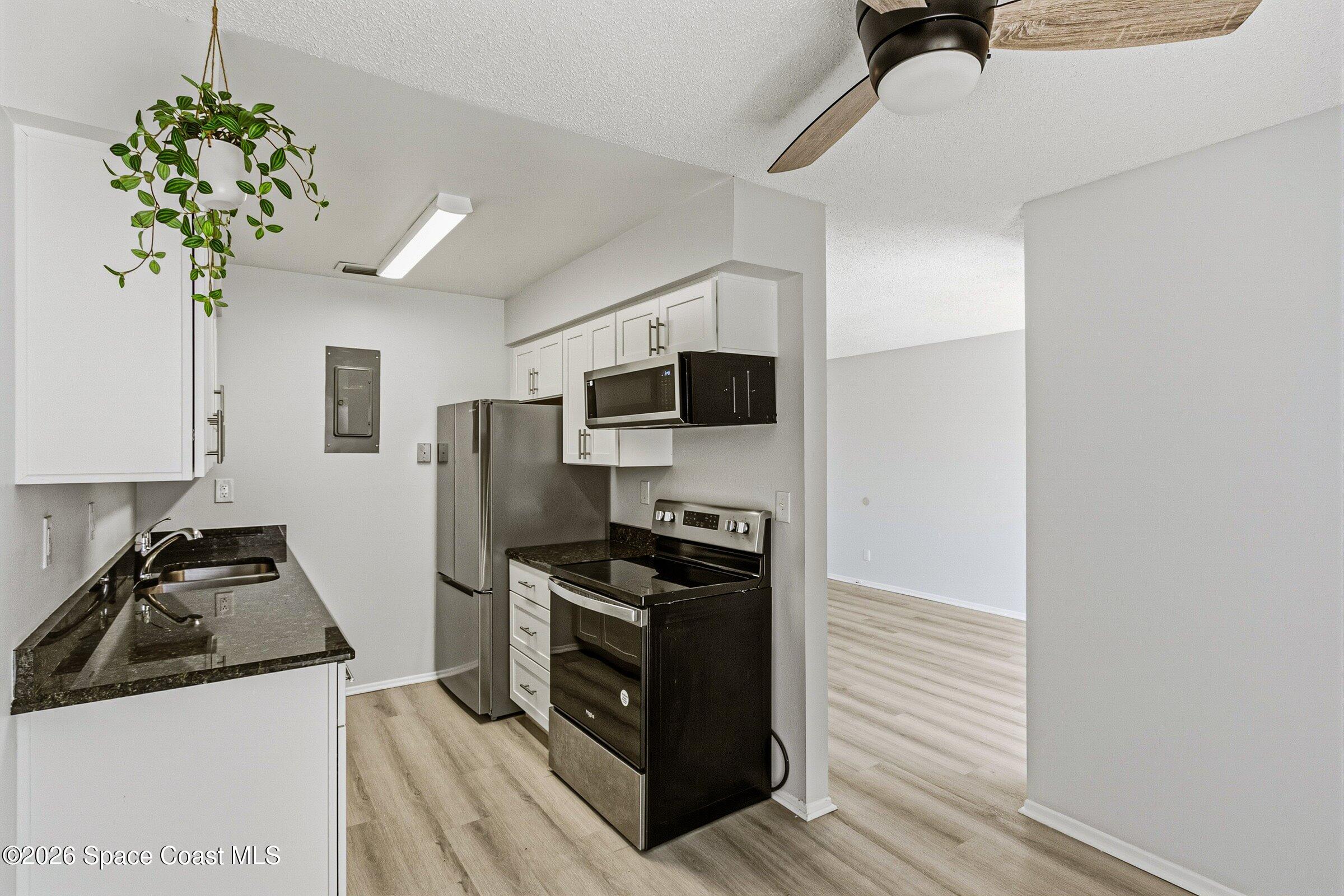 1225 North Wickham Road, Unit 223 Melbourne, FL 32935 - Photo 8 of 26 a kitchen with a stove a refrigerator and a sink