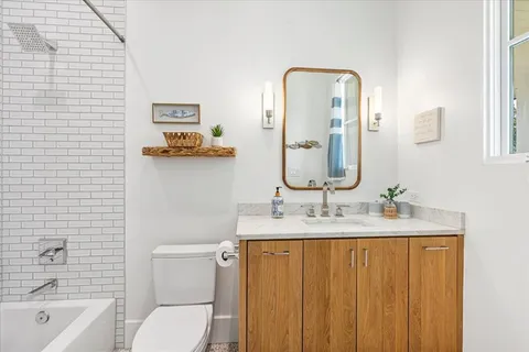 a bathroom with a toilet sink and mirror