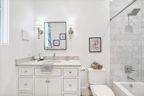 a bathroom with a granite countertop sink mirror vanity and toilet