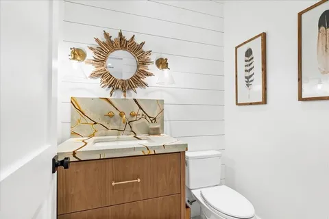 a bathroom with a toilet sink and mirror