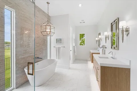 a spacious bathroom with a tub sink and mirror
