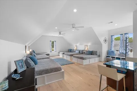 a living room with couches and kitchen view with wooden floor