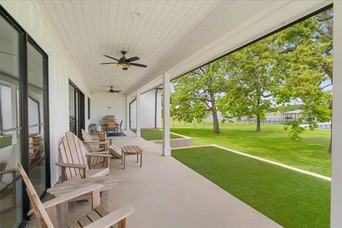 a view of a patio with a table chairs and a yard