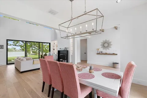 a dining room with furniture a chandelier and wooden floor