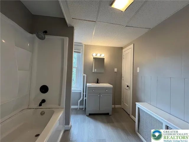 a bathroom with a bathtub shower and sink