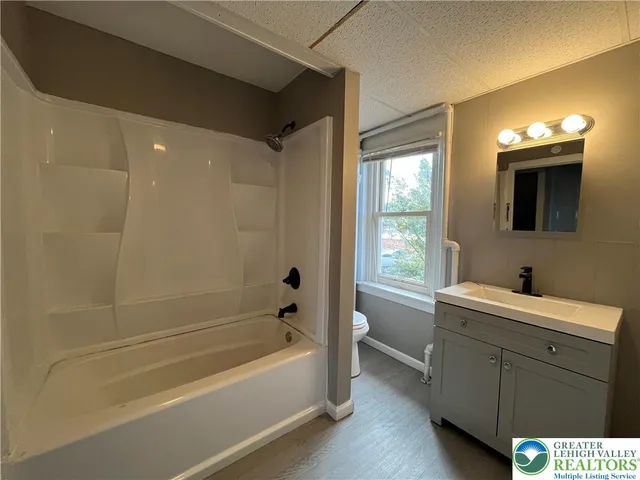 a bathroom with a sink a bathtub and a vanity