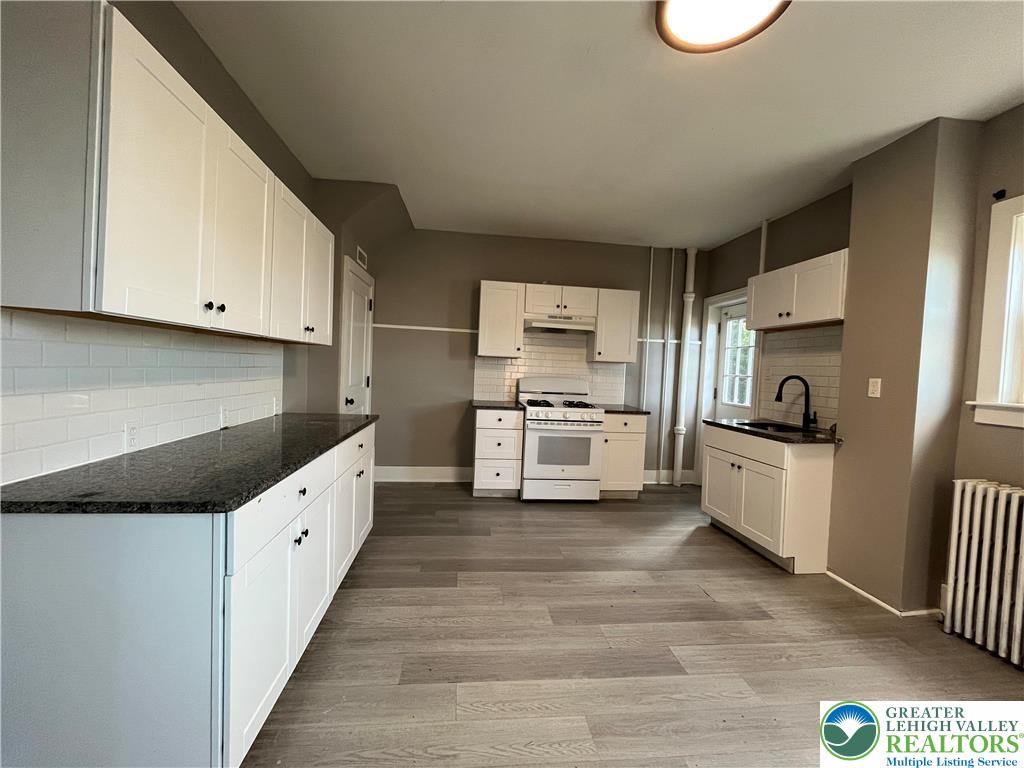 2402-2404 South 4th Street Allentown, PA 18103 - Photo 5 of 21 a kitchen with granite countertop white cabinets and white appliances