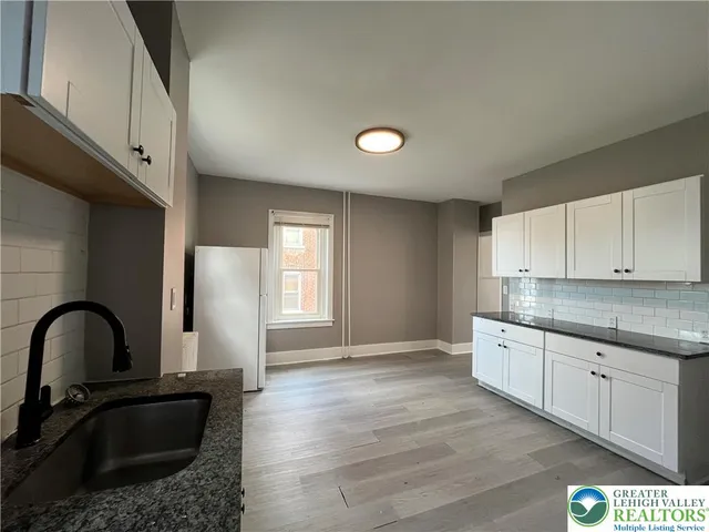 a kitchen with granite countertop a stove a sink and a window