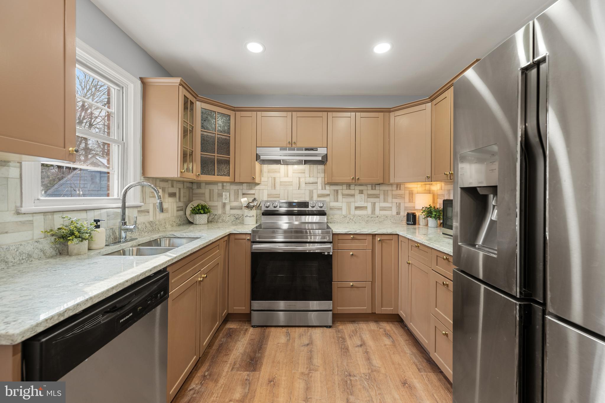 6439 Bock Road Oxon Hill, MD 20745 - Photo 7 of 38 a kitchen with a sink a refrigerator and white cabinets