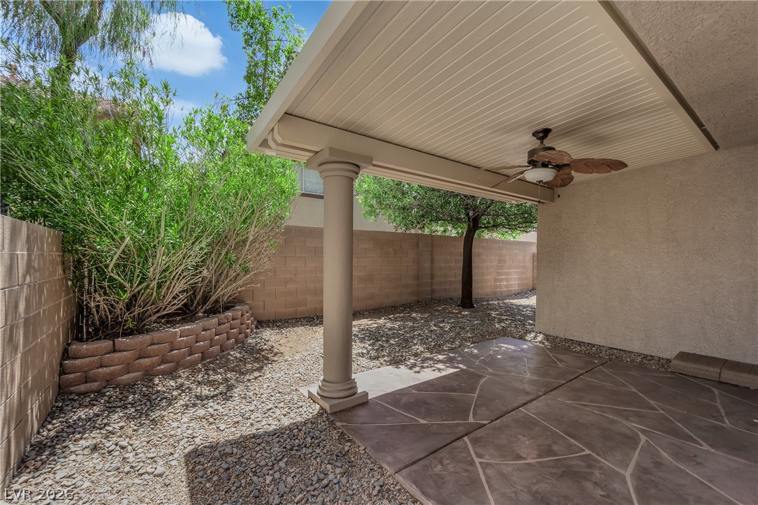 646 Monument Point Street Henderson, NV 89002 - Photo 29 of 44 A spacious covered patio features a ceiling fan, offering a tranquil outdoor retreat.