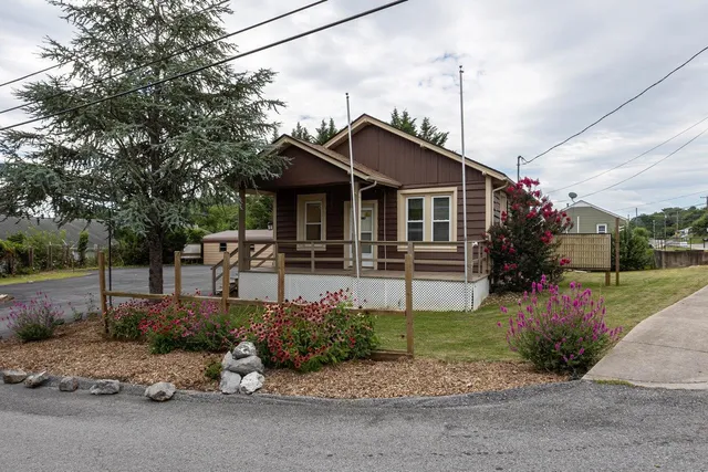 a front view of a house with a garden and plants