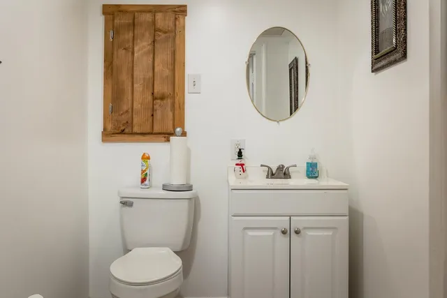 a bathroom with a toilet a sink and a mirror