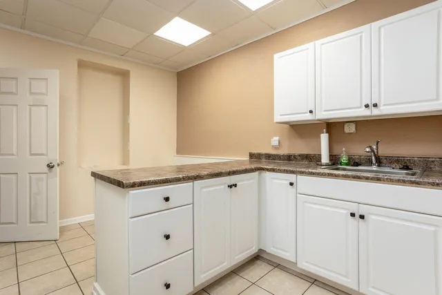 a kitchen with granite countertop white cabinets and sink