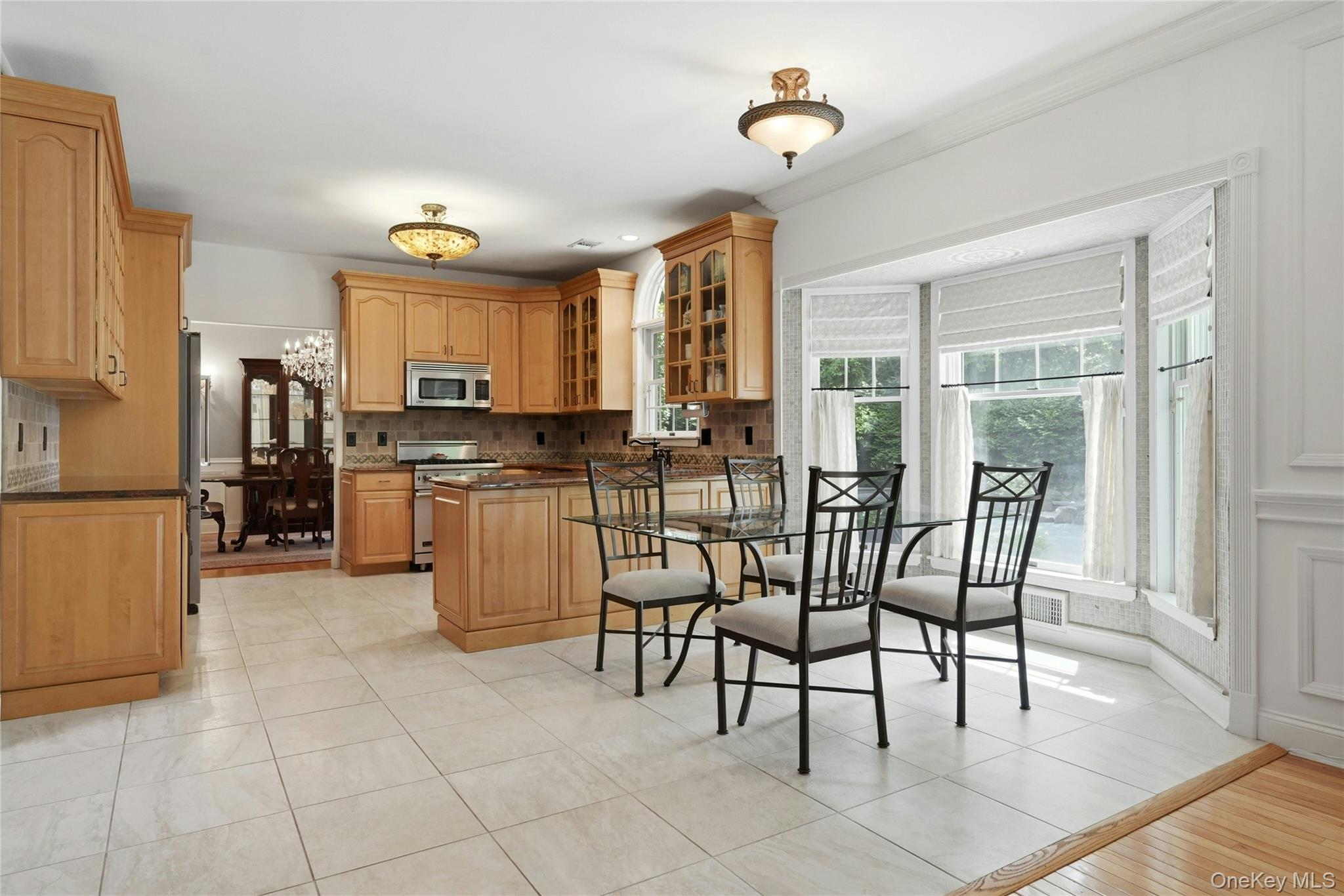 6 Thunder Road Miller Place, NY 11764 - Photo 17 of 50 The Spectacular Three Year Old Chef's Kitchen Offers Walls Of Extra Height Custom Maple Cabinetry With Beautiful Moldings, Detailwork & Trims, Glass Doors, Premium Granite Countertops With Expansive Counter/Serving Areas, Tiled Backsplash With Accent Border, Stunning Circle Topped Window Over The Sink, A Suite Of Viking Stainless Steel Appliances (Including A Gas Range), Porcelain Tiled Floors & A Large Dinette Area Which Opens Into The Family Room/Den.