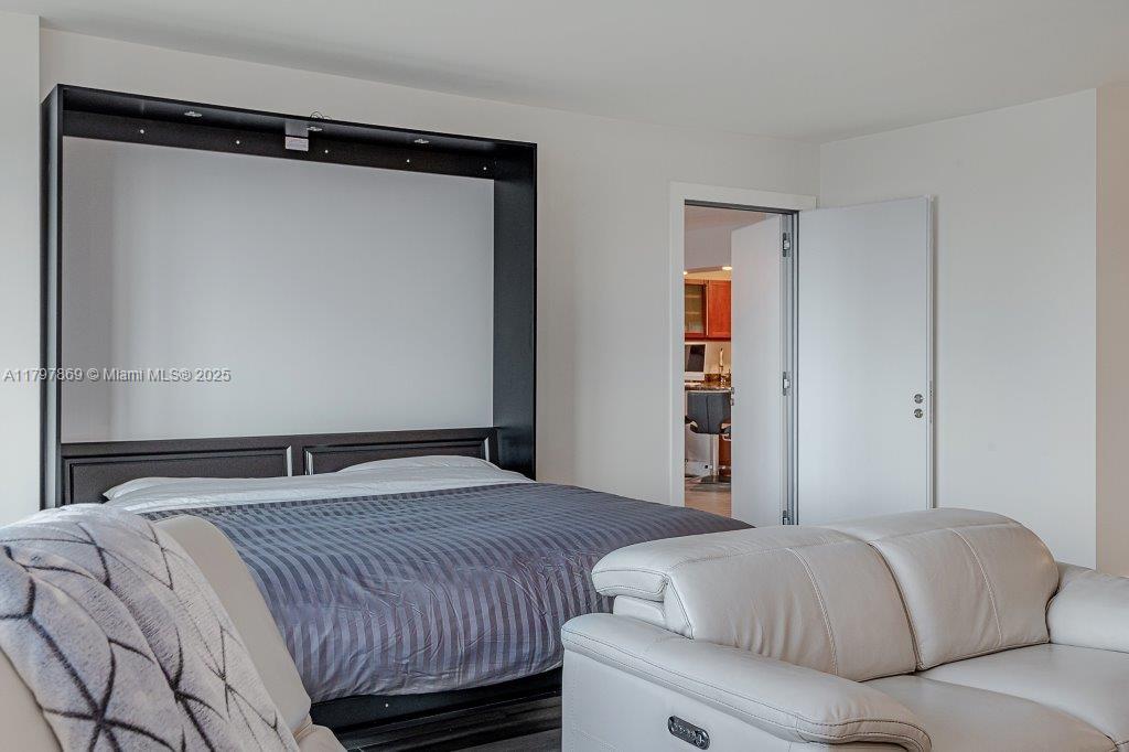 2301 Collins Avenue, Unit 1532 Miami Beach, FL 33139 - Photo 18 of 28 a bedroom with a bed and a mirror