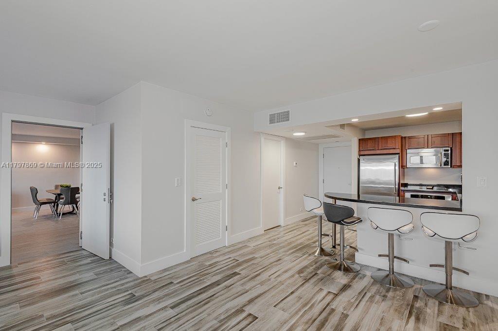 2301 Collins Avenue, Unit 1532 Miami Beach, FL 33139 - Photo 20 of 28 a workspace room with wooden floor table and chairs