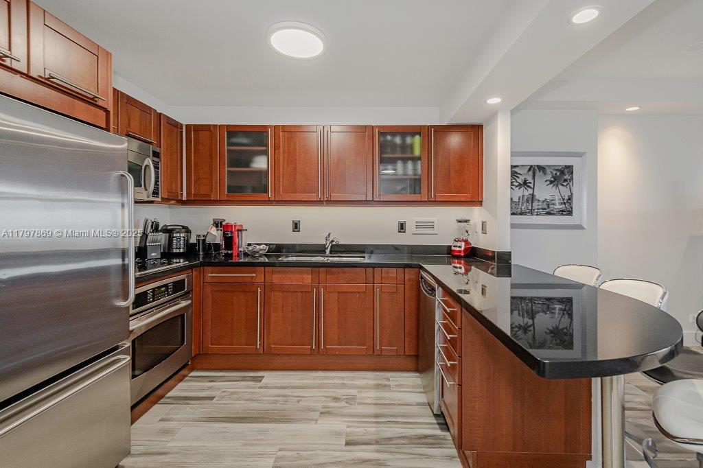 2301 Collins Avenue, Unit 1532 Miami Beach, FL 33139 - Photo 24 of 28 a kitchen with stainless steel appliances granite countertop a refrigerator and a sink