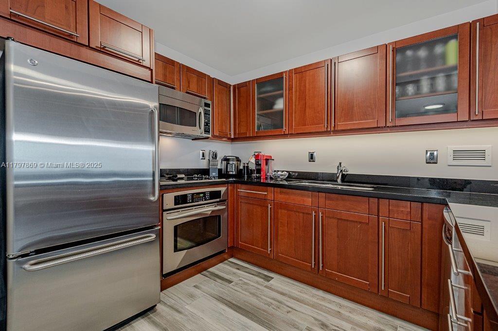 2301 Collins Avenue, Unit 1532 Miami Beach, FL 33139 - Photo 25 of 28 a kitchen with stainless steel appliances granite countertop a refrigerator and a sink