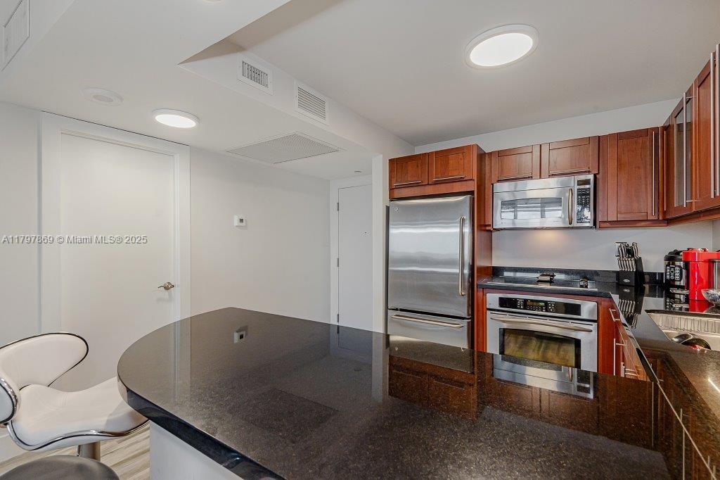 2301 Collins Avenue, Unit 1532 Miami Beach, FL 33139 - Photo 26 of 28 a kitchen with stainless steel appliances granite countertop a refrigerator stove and sink