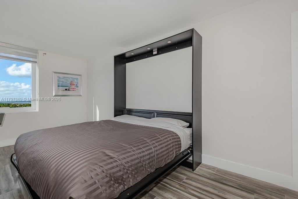 2301 Collins Avenue, Unit 1532 Miami Beach, FL 33139 - Photo 9 of 28 a bedroom with a bed and wooden floor