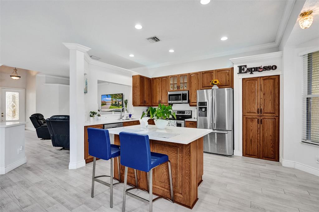 13129 Southwest 32nd Street Miramar, FL 33027 - Photo 11 of 38 a kitchen with stainless steel appliances granite countertop a refrigerator a sink a stove a dining table and chairs