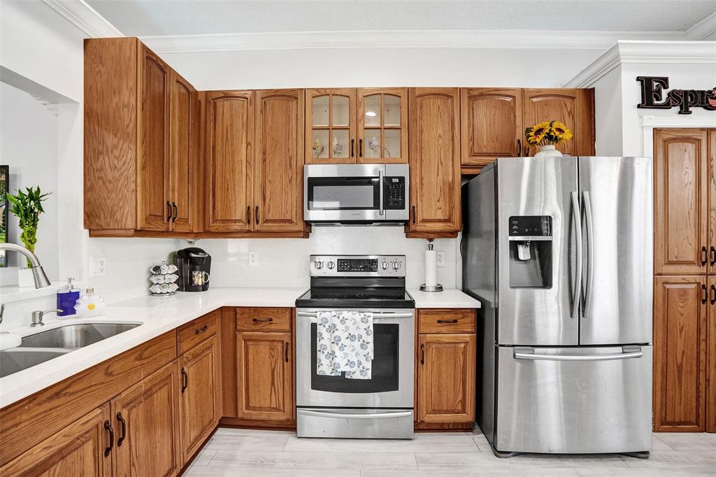 13129 Southwest 32nd Street Miramar, FL 33027 - Photo 12 of 38 a kitchen with granite countertop a refrigerator stove and microwave