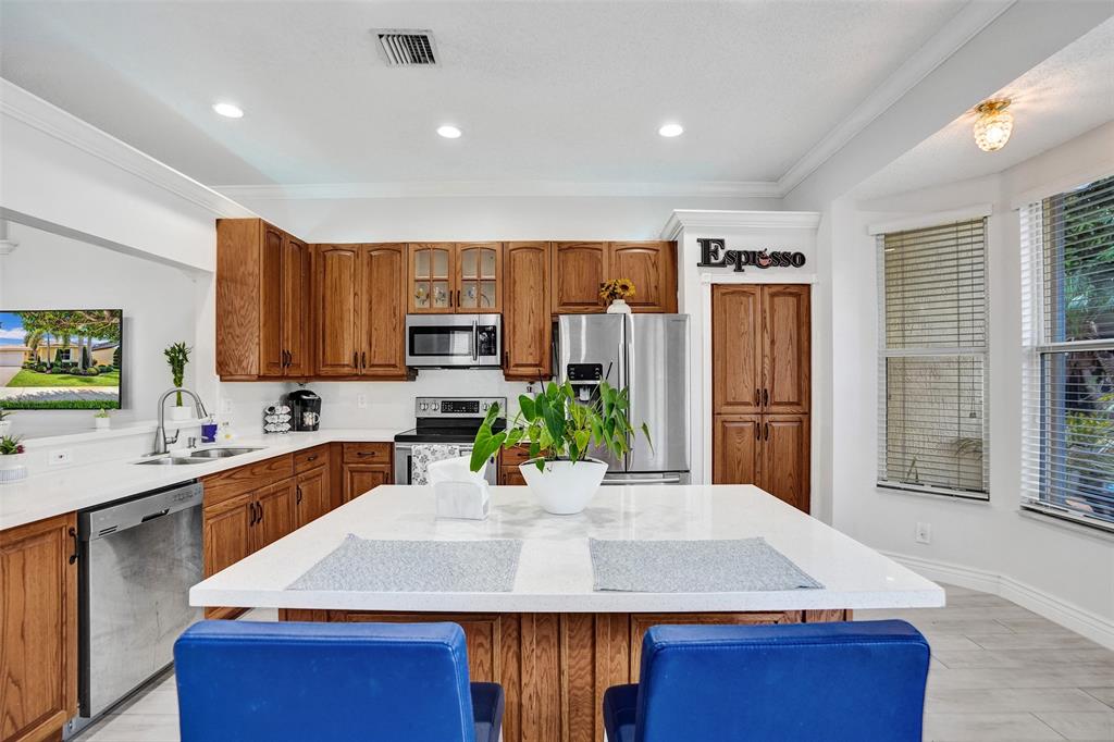 13129 Southwest 32nd Street Miramar, FL 33027 - Photo 13 of 38 a kitchen with kitchen island a sink stove and refrigerator